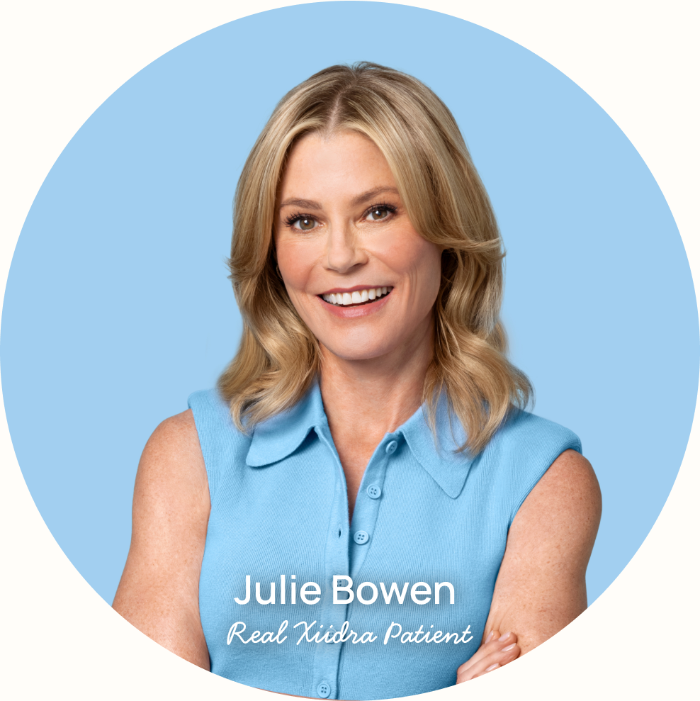 Julie Bowen looking smiling at the camera with the words "Julie Bowen real Xiidra patient" at the bottom and a play button in the top right corner