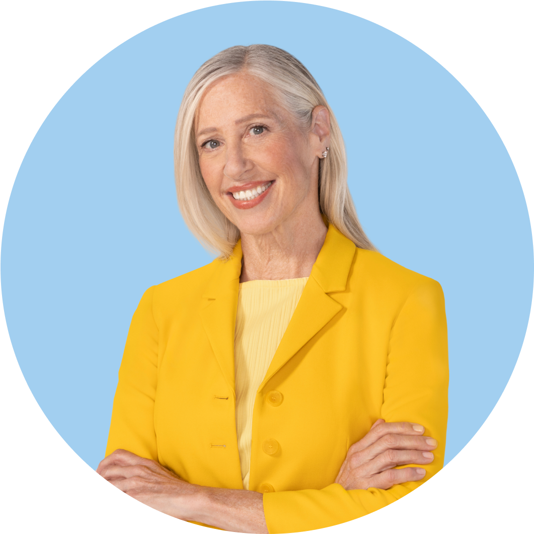 White woman with blond hair in a yellow outfit smiling
